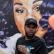 Kenneth Walker, boyfriend of Breonna Taylor, stands in front of a portrait of Taylor during a protest memorial for her in Jefferson Square Park on March 13, 2021 in Louisville, Kentucky. Today marks the one year anniversary since Taylor was killed in her apartment during a botched no-knock raid executed by LMPD.